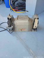 Photo of the Thor Speed Tool bench grinder showing the grinding and buffing wheels with cord attached