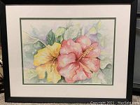 Framed watercolor painting of two hibiscus flowers, pink and yellow, with green leaves.