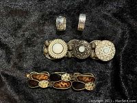 Top-down image of two sterling silver rings with detailed leaf and Southwest patterns, and two stretch bracelets with mixed metal and resin elements.