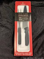 Full view of the Victorinox Swiss Classic 2-piece carving set in original packaging, showing knife and fork with black handles.