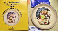 Photo of the Goebel M.J. Hummel 1975 first edition anniversary plate in original yellow box with blue certificate booklet.
