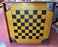 Front side shows a black on natural wood checkerboard pattern with web pockets in corners