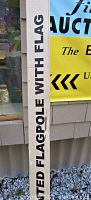 Photo of flagpole packaging showing partial text '6.5 Foot Wall Mounted Flagpole with Flag'