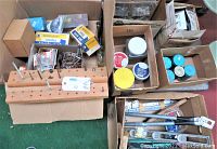 Multiple cardboard boxes filled with assorted fasteners, jars of screws, nuts, nails, and electrical components.