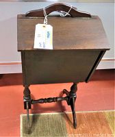 Front view of the vintage wooden sewing box stand showing hinged lid and wooden handle on top