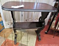 Front and side view of dark wood side table with lower shelf and metal magazine rack in front