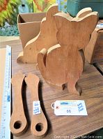 Photo showing wooden blocks including a sitting cat-shaped block and two wrench-shaped wooden blocks on a table with a ruler for scale.