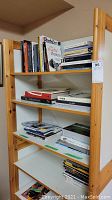 Wooden bookshelf with multiple shelves filled with various books including photography titles and other art-related books.