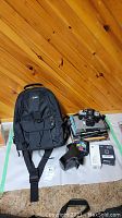 Overall view of Nikon camera, backpack, cases, books and accessories