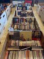 Three banker boxes filled with jewel-case audio CDs, view from above