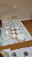 All Noritake Damon pieces laid out on floor: plates, bowls, cups, saucers, teapot, creamer, sugar bowl, tureen.