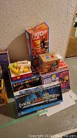 Overview showing assembled lot with Payoff Machine, motorized Erector set, Lite-Brite, and Putt-Putt sets boxed.