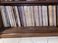 Shelf of many vinyl records upright, titles include classical composers Haydn, Mozart among others. Records show age wear.