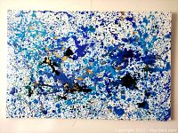 Front view of entire canvas showing white background with blue, teal, gold and black splatters