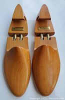 Top view of the wooden shoe trees showing the smooth polished wood surface and metal adjustment parts with Burberry brand plates.
