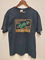 Front view of the black T-shirt showing the Reynolds logo and text graphic.