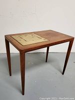 Angled view of the teak side table showing tapered legs and tile inset detail on tabletop.