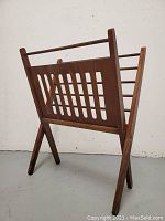 Front three-quarter view of teak magazine rack standing folded open