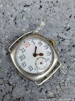 Front view of the sterling silver cased trench watch showing the porcelain dial with Arabic numerals and cathedral hands, sub-second dial at 6 o'clock.
