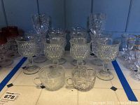 Front view of all glassware items including Shannon Crystal wine glasses, pressed glass goblets, and teacups