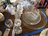 Top view of glassware set showing candles in holders, a tall jar with lid, cups, dishes, and two platters.