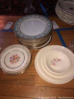 Stack of plates showing Lenox snack and dinner plates with decorative borders and floral patterns