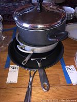 Stacked boiling pot with cover and frying pans showing handles and condition