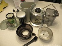 All disassembled components of the Breville Juice Fountain Plus juicer - pulp container, juice jug, feed chute, filter basket, juicing bowl, plunger, cleaning brush