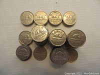Coins stacked and displayed, showing beaver nickel Canadian 5 cent coins dating 1939 to 1949, various quantities.