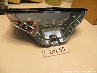 Front and top view of Victorian style knickknack shelf showing etched mirrored floral panel and scalloped wooden frame.