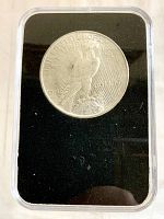 Reverse side of the 1922 Peace Silver Dollar showing the eagle and inscriptions, within a plastic protective case.