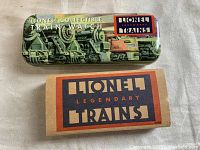 Metal tin with Lionel collectible train watch branding featuring vintage train graphics, showing the box exterior.