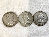 Front sides of three Benjamin Franklin half dollars dated 1949, 1958, and 1950 with visible wear.