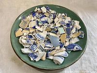 Plate filled with various blue and white pottery shards of different sizes and patterns.
