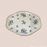 Top-down photo of the Tiffany & Co porcelain platter, showing the Forget Me Not blue floral pattern and gold trimmed scalloped edge on white porcelain.