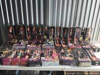 Overall display of 21 Bratz dolls in original packaging on folding table