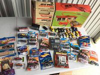 Overview photo showing Hot Wheels Supercharger Track Set box and multiple unopened and opened Hot Wheels and Matchbox cars on table.