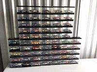 Overall view of seven rows of die-cast NASCAR model cars in clear display cases