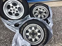 General view of three of the four silver alloy wheels wrapped in plastic