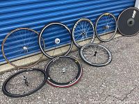 Overview of all eight wheels leaning and on ground against blue metal door