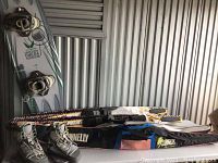 Photo showing two Dunnelly water skis in storage bags and a Liquid Force wakeboard with bindings.