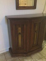 Front and side view of the wooden hall cabinet showing carved panels and brass inset
