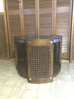 Side view of the retro round table showing the tubular wood frame with rattan inserts on the side panels and round shape.