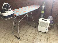 Overall view of ironing board, steam iron on base, dehumidifier, vacuum and steam mop