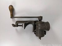 Top side view showing the full length of the food grinder with wooden handle and clamp mechanism.