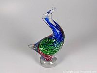 Clear side view of the art glass goose shaped paperweight showing multi color swirl