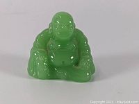 Front view of green jade Buddha figurine showing face and detailed carving