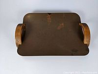 Top view of the rectangular copper serving tray with wooden handles, showing patina and surface wear.