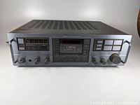 Front view of Carver Magnetic Field Power Amplifier showing brushed aluminum front panel, knobs, input buttons and LED display