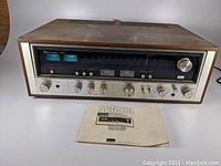 Front view of Sansui 8080 receiver with manual placed in front